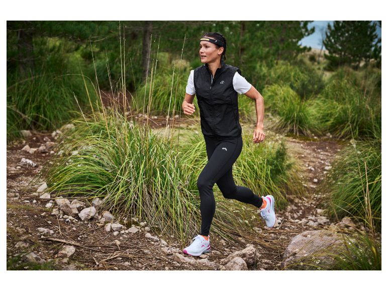 Vrouw trailrunnend in Kalenji kleding en schoenen.