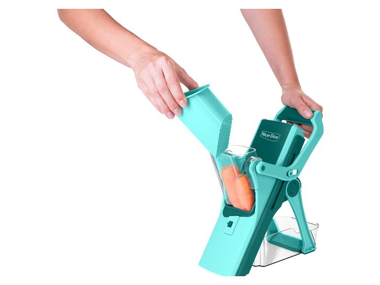 Nicer Dicer turquoise groentesnijder met wortels, vastgehouden door handen