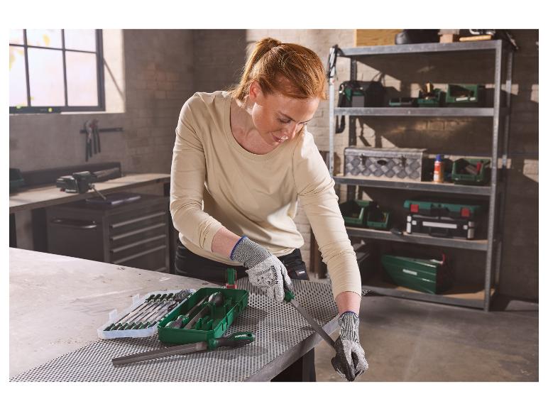 Vrouw vijlt metaal met PARKSIDE® werkplaatsvijlenset in een werkplaats.
