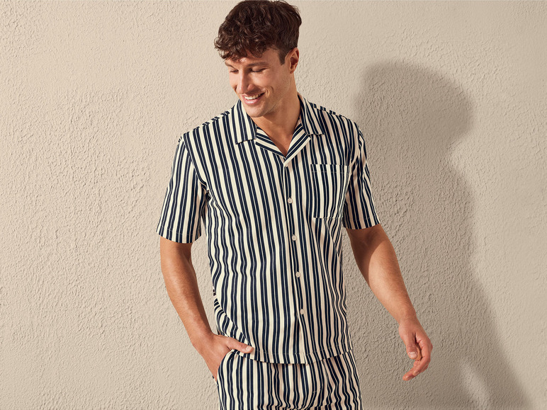 Man draagt een gestreept overhemd en broek in een loungewear stijl.