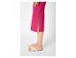 Vrouw in fuchsia geribbelde midirok met zijsplit en beige platte sandalen