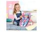 Meisje speelt met een BABY born pop in een roze autostoel.