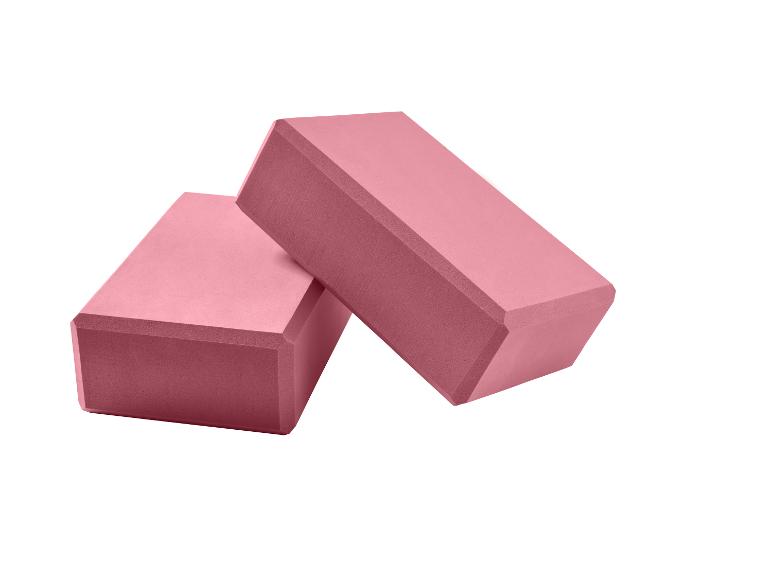 Twee roze yogablokken op een witte achtergrond.