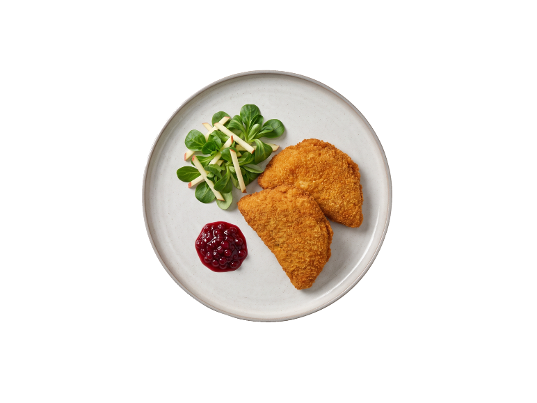 Gepaneerde kaas met vossenbessenbessencompote en frisse salade op een bord.