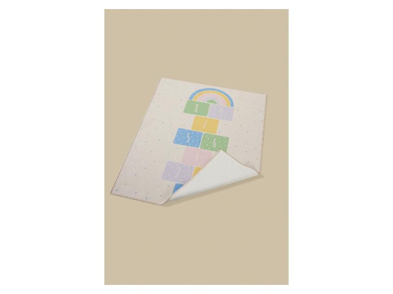 Kinderkleed met hinkelbaan en regenboogpatroon op een beige achtergrond.