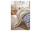 Zachte LIVARNO home deken op een bed met blauw-wit beddengoed.