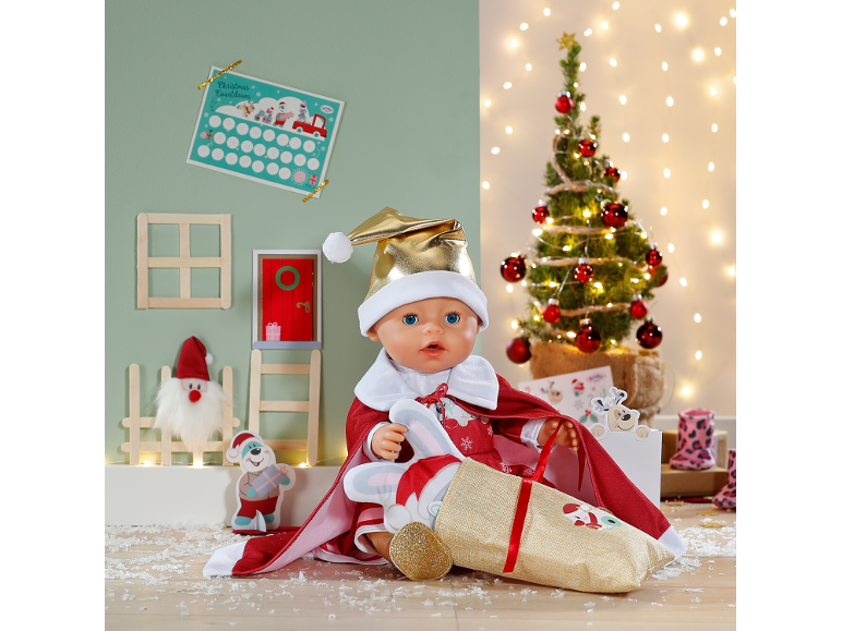 Babypop in kerstmanpak met een cadeauzak voor een feestelijke achtergrond.