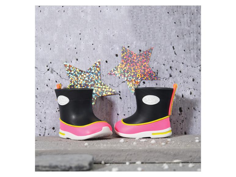 Zwarte en roze kinderregenlaarzen met gele details, met glimmende sterren op de achtergrond.