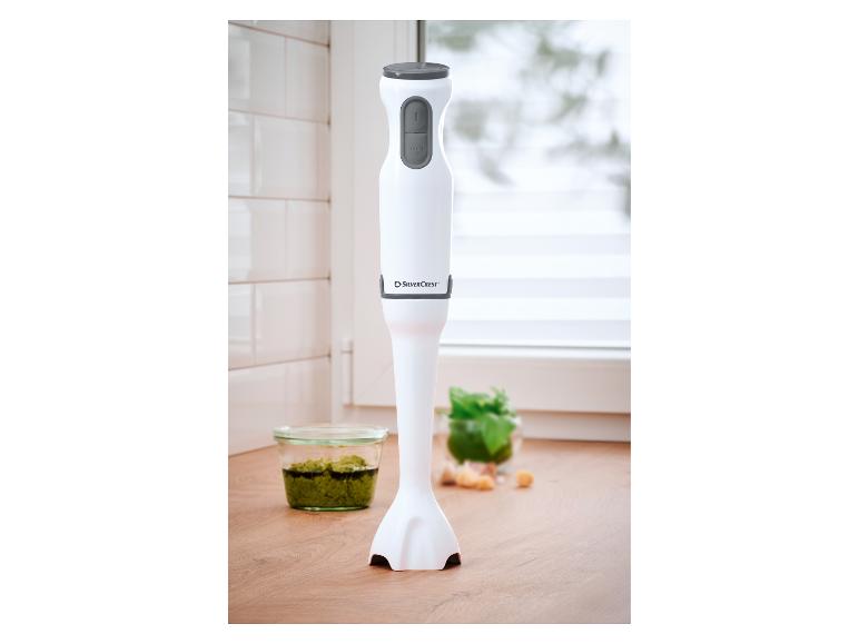 Witte SilverCrest staafmixer met grijze knoppen, naast een kom pesto.