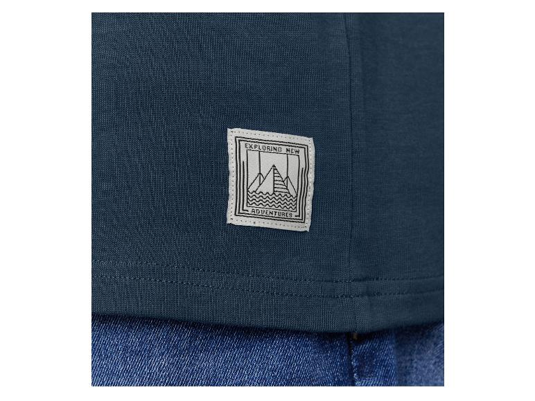 Een donkerblauwe T-shirt met een label met de tekst 'Exploring New Adventures'.