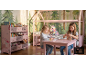 Twee meisjes spelen in een roze kinderkamer met huisbed en speelgoedrek.