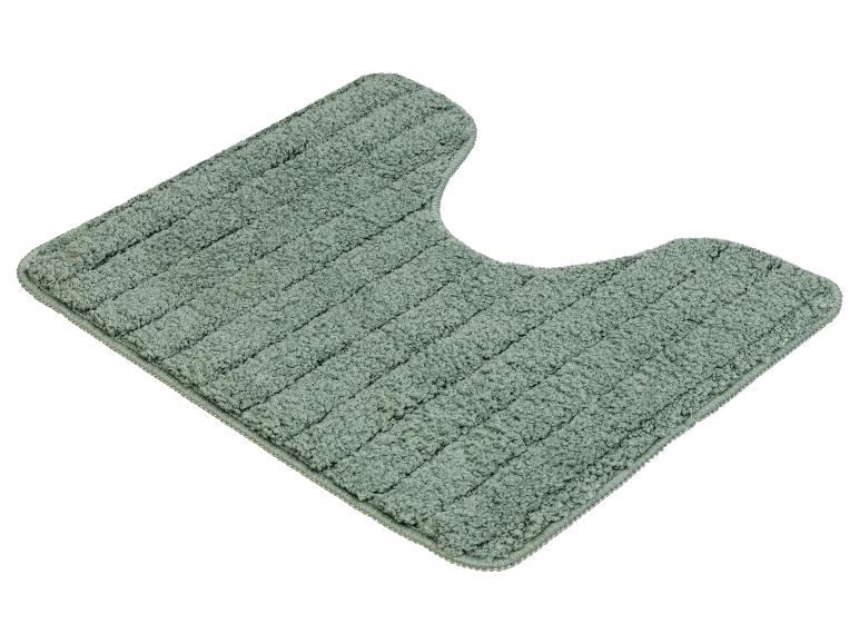 Een groene badmat met een uitsparing voor de toiletpot.