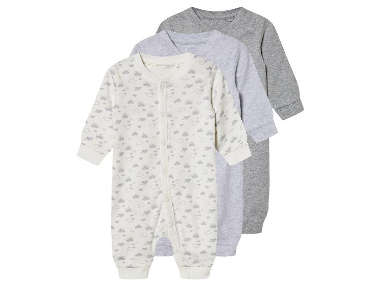 Drie baby slaappakken: één met wolkjesprint, twee grijze effen.