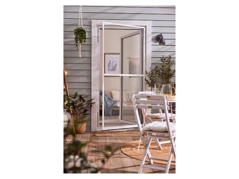 Open hor in terrasdeur met tuinmeubelen en planten.