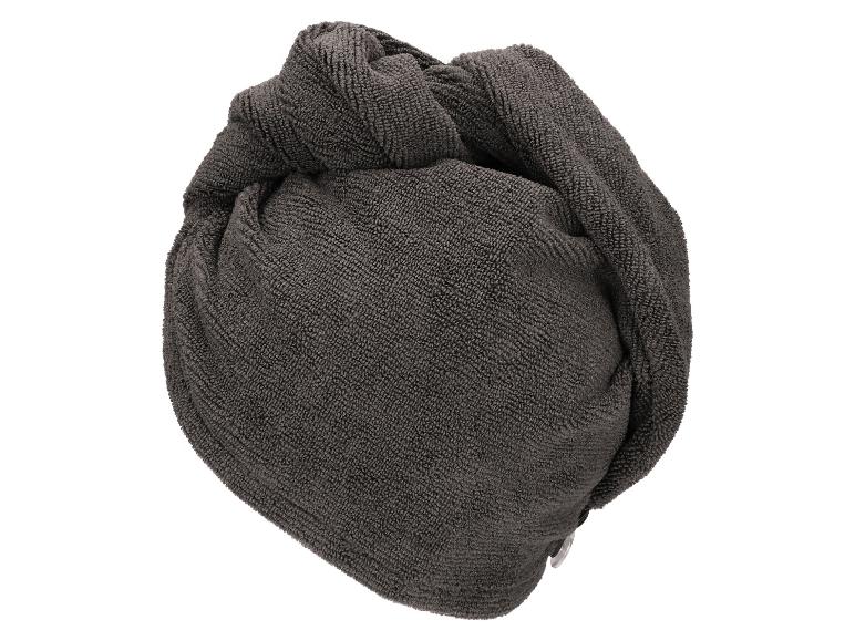 Donkergrijze handdoek voor haar, opgerold en klaar voor gebruik.