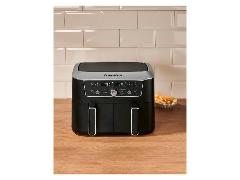 Dubbele heteluchtfriteuse met frietjes op een houten aanrecht.