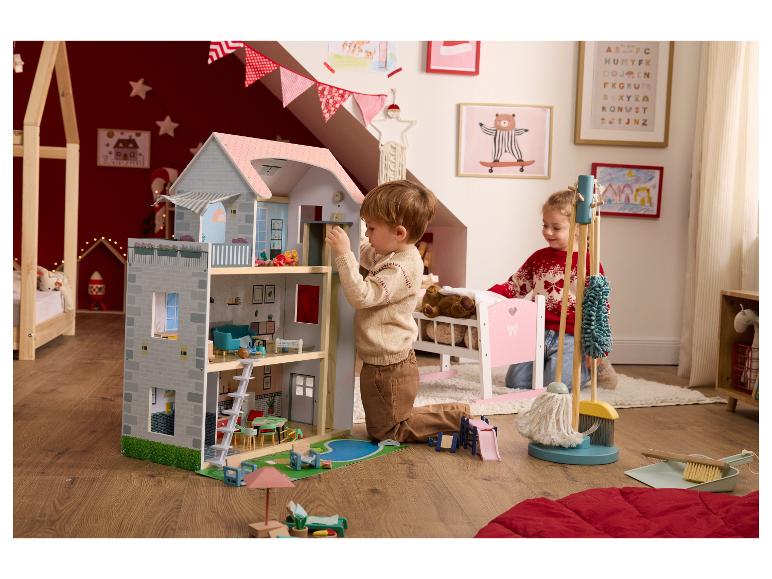 Twee kinderen spelen met een groot poppenhuis en een schoonmaakset.