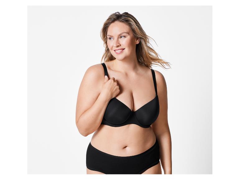 Een vrouw draagt een zwarte bh en slip.