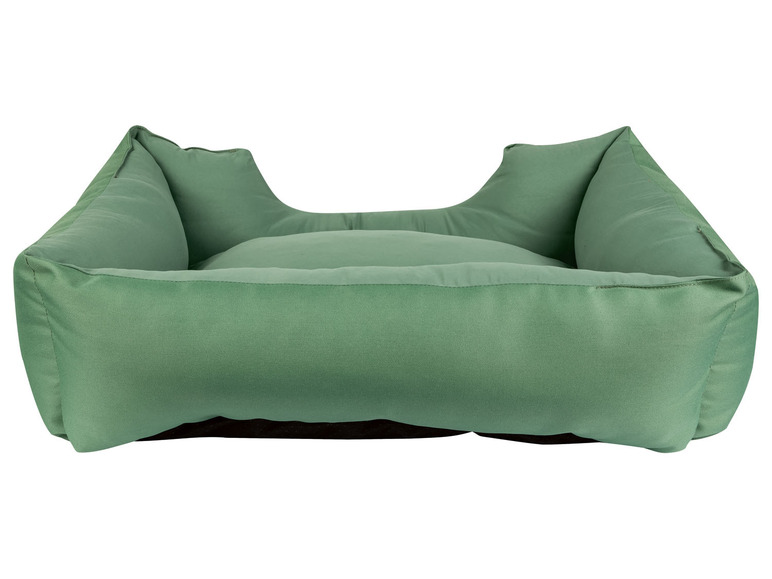 Een groene hondenmand met een kussen.