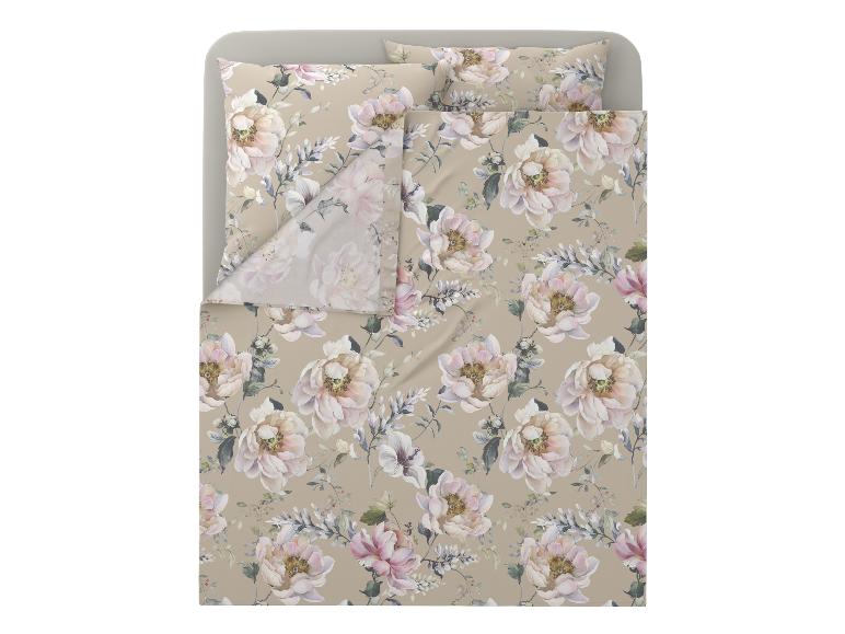 Bloemig beddengoed in beige en roze tinten op een bed.