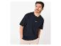 Man in marineblauw T-shirt met basketbalmotief en beige broek, kijkt opzij.