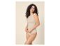 Lachende vrouw met krullend haar draagt een huidkleurige top en slip.