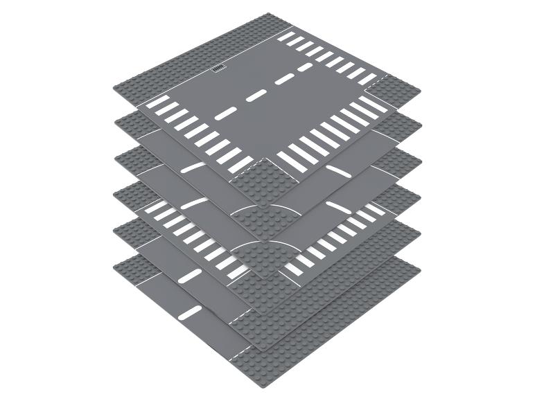 Stapel grijze LEGO-wegplaten met kruispunten, rechte stukken en zebrapaden.