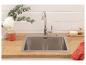 Keukenspoelbak met kraan, houten aanrechtblad, witte bakstenen muur, eucalyptus takken.