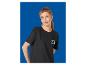 Vrouw in een zwart T-shirt met een kleurrijk logo, poserend voor een blauwe achtergrond.