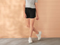 Zwarte shorts en witte sneakers voor dames.