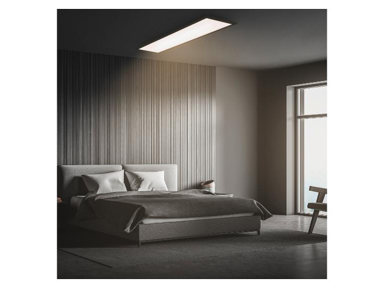 Een moderne slaapkamer met een bed, een houten wandpaneel en een rechthoekige plafondlamp.