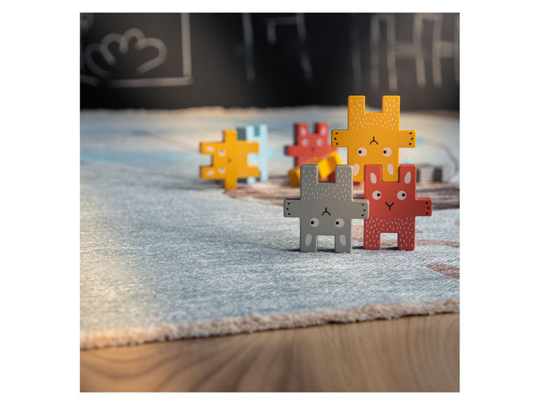 Houten puzzelstukken met dierlijke motieven op een vloerkleed.