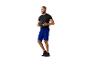 Man in zwart shirt en blauwe shorts houdt een GripFit trainingsbal vast.