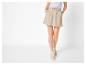 Dames beige skort met trekkoord en licht gestreept overhemd.