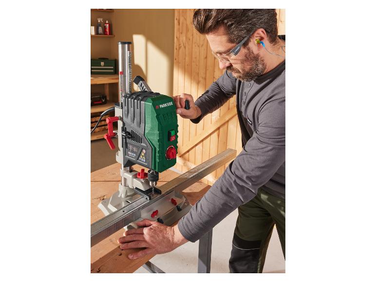 Een man gebruikt een Parkside boormachine voor houtbewerking.