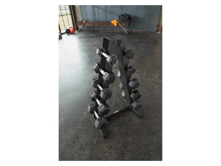 Een zwart halterrek met diverse gewogen halters in een sportschoolomgeving.