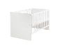 Eenvoudig wit babybedje met spijlen en dichte zijkanten.