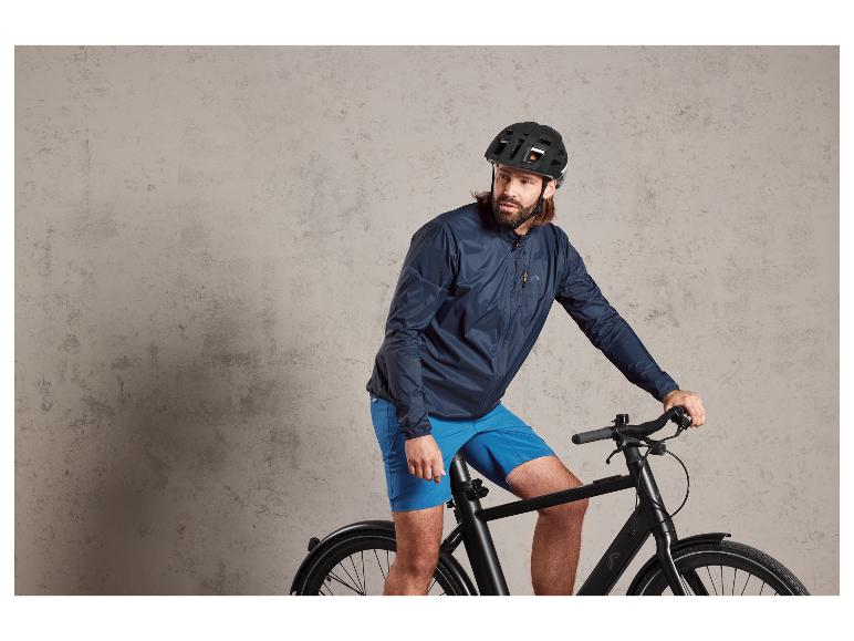 Man met helm op een zwarte fiets.