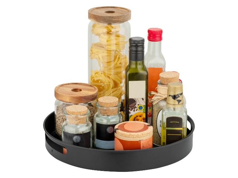 Draaiplateau met pasta, olie, azijn en kruiden in glazen potten en flessen.