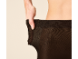 Vrouw trekt aan zwarte panty, toont de elasticiteit.
