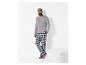 Man in grijze longsleeve en geruite pyjamabroek.