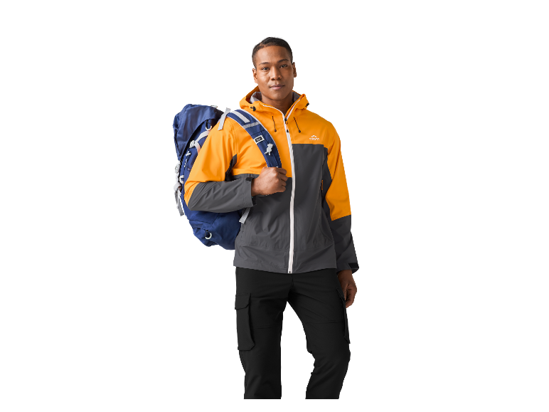 Man in een oranje en grijze outdoorjas met een blauwe rugzak.