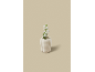 Een witte keramische vaas met een witte bloem op een beige achtergrond.