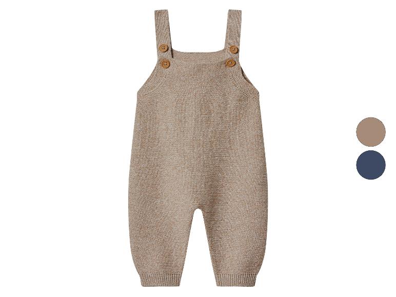 Gebreide baby-overal in beige met houten knopen en kleurstalen.