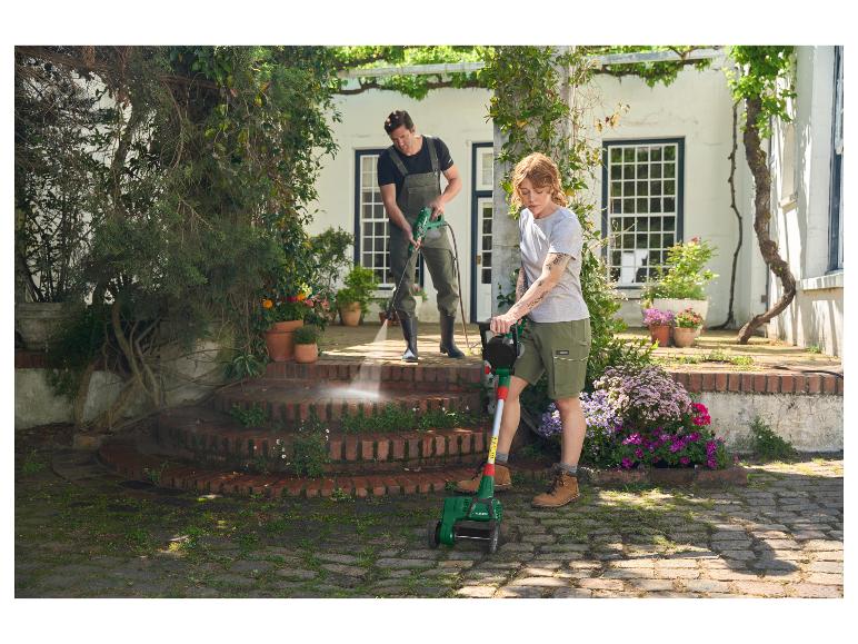 Man met hogedrukreiniger en vrouw met Parkside onkruidverwijderaar reinigen de tuin.