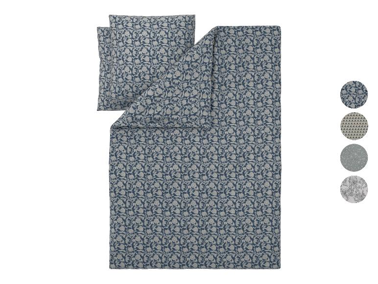 Blauw dekbedovertrek met bloemenpatroon, kussensloop en stalen.