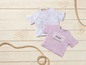 Twee roze T-shirts met zomerse prints, waaronder een met 'Malibu Sunset Paradise Beach'