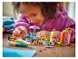 Een meisje speelt met een LEGO Friends set, met een boot, eethoek en strand.