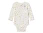 Witte baby romper met roze, gele en blauwe stippen.