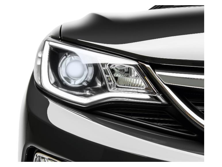 Close-up van de koplamp van een zwarte auto.